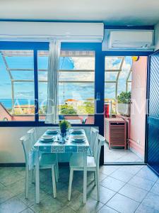 ein Esszimmer mit Tisch und Stühlen und einem Fenster in der Unterkunft Raffaella 2 in Campese