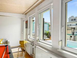 ein Zimmer mit drei Fenstern und Blick auf einen Balkon in der Unterkunft Stuttgart Sky & Comfort Apartments in Stuttgart