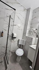 a bathroom with a toilet and a glass shower at Hotel Sir Lujerului in Bucharest