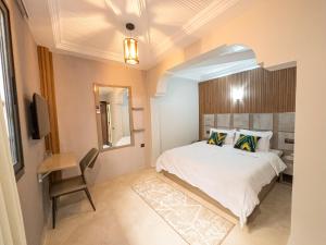 a bedroom with a bed and a table and a chair at Agadir Gardens Center Hotel in Agadir