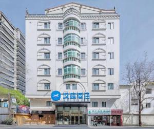 ein weißes Gebäude mit einem blauen Schild darauf in der Unterkunft Hi Inn Shanghai Zhongshan Park Branch in Shanghai