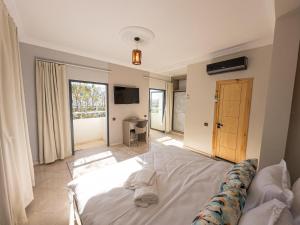 a bedroom with a large white bed and a television at Agadir Gardens Center Hotel in Agadir +14 photos