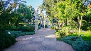 a walkway in a park with trees and plants at Agadir Gardens Center Hotel in Agadir