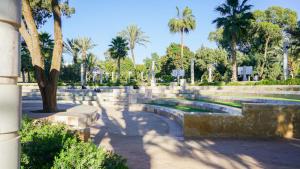 a park with palm trees and a fountain at Agadir Gardens Center Hotel in Agadir