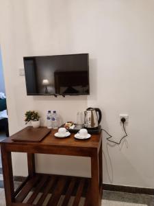 a wooden table with a television on a wall at Astoria Cottage in Nuwara Eliya