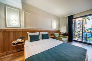 a bedroom with a large bed and a large window at Eflina Resort Hotel&Spa in Alanya