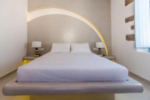 a bedroom with a white bed with an arch above it at Plaka Suites in Plaka Milou