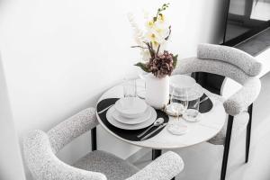 einen Tisch mit zwei Stühlen und eine Vase mit Blumen in der Unterkunft StayShort - Serene Studio in DAMAC Hills near Golf Course - Sleeps 2 in Dubai Marina