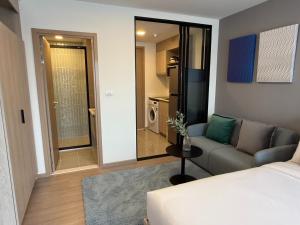 Apartment The Base Bukit Phuket في فوكيت تاون: غرفة معيشة بها سرير وأريكة