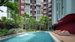 Apartment The Base Bukit Phuket في فوكيت تاون: حمام سباحة أمام مبنى شاهق