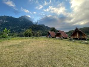 NongkhiawPhoutthasack Guesthouse的一组以山脉为背景的小屋