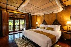 a bedroom with a large bed in a room at Lampang River Retreat in Lampang