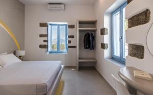 a small bedroom with a bed and a window at Plaka Suites in Plaka Milou