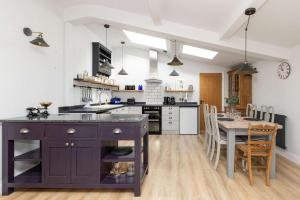 a kitchen with a table and a dining room at Sidlesham Hideaway Logburner & Garden in Donnington