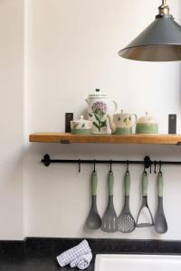 a shelf above a stove with vases and a lamp at Sidlesham Hideaway Logburner & Garden in Donnington +30 photos