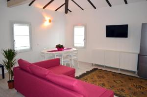 a living room with a pink couch and a table at Casa Leone 1 in Caorle