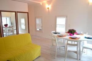 a living room with a table and a yellow couch at Casa Leone 1 in Caorle