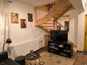 a living room with a couch and a tv at Villa Zlatica in Kupjak