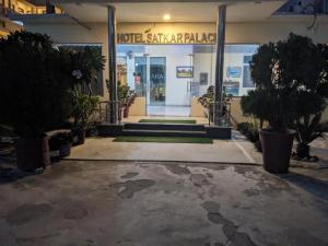 een vooringang van een gebouw met bomen ervoor bij Satkar palace hotel 