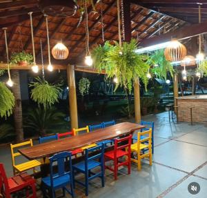 a wooden table and colorful chairs in a restaurant at Hotel GAPH Maringa - Economico Mini Resort in Maringá
