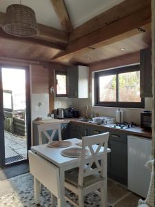 une cuisine avec une table et deux chaises blanches dans l'établissement La Tour, à Châtillon-sur-Seine