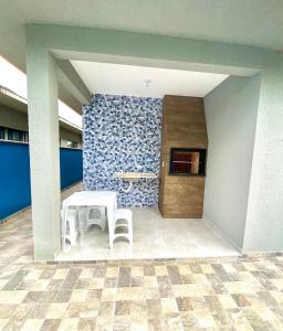 ein Tisch und zwei Hocker in einem Raum mit einer Wand in der Unterkunft Casa c ar condicionado à 600m mar in Itapoa