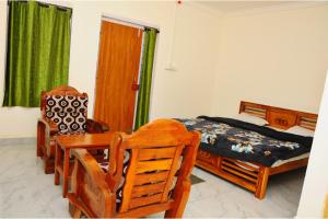 a bedroom with a bed and a table and chairs at Kitty Royal Inn in Ooty