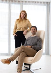 a woman standing next to a man sitting in a chair at Hotel loj - our kind of place in Flachau