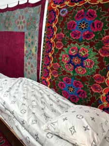 een bed met een deken met bloemenpatroon en een bed sidx sidx sidx bij Cheber Guest House 