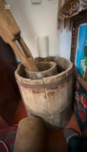 een emmer met twee houten gebruiksvoorwerpen erin bij Cheber Guest House 