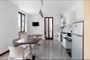una cucina bianca con tavolo e una sala da pranzo di La Terrazza Guest House a San Zeno