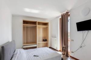 una camera da letto con un letto e una TV a schermo piatto di La Terrazza Guest House a San Zeno