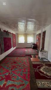 een lege kamer met een groot tapijt aan de muren bij Cheber Guest House 