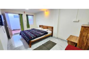 a bedroom with a bed and a window at Kitty Royal Inn in Ooty