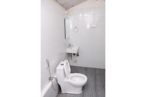 a white bathroom with a toilet and a sink at Kitty Royal Inn in Ooty +35 photos
