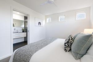 une chambre blanche avec un lit et une salle de bain dans l'établissement Olive & Salt, à Mornington