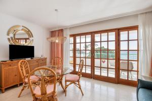 ein Esszimmer mit Tisch und Stühlen und einem Fernseher in der Unterkunft Playa Delphin 106 in Puerto Naos