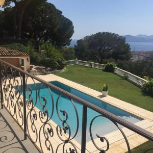 a balcony with a swimming pool and a yard at Villa Soley in Cannes