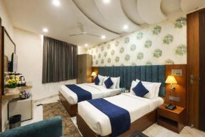 a hotel room with two beds and a couch at Hotel Lotus Arc NEAR IGI AIRPORT in New Delhi