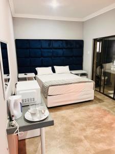 una camera da letto con un letto e un tavolo con tazze di Dzire Guesthouse a Thohoyandou