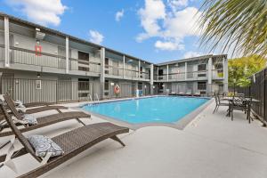 a pool at a hotel with chairs and a patio at Super 8 by Wyndham Texas City in Texas City