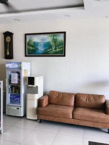 a living room with a couch and a refrigerator at Power Hotel in Kampong Sungai Gelugor