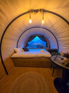 una camera da letto con un letto in una tenda di Nomad by Hora cu Brazi a Zărneşti