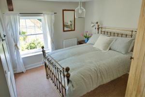 een slaapkamer met een groot bed en een raam bij Finest Retreats - Meadowsweet Cottage in Wingfield