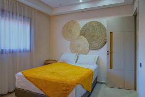 a bedroom with a bed with a yellow blanket on it at Charming Seaside Apartment with Pool & Direct Beach Access in Agadir nʼ Aït Sa +30 photos
