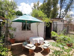 a table and chairs and an umbrella in a yard at Cottage on Roux in Smithfield +10 photos