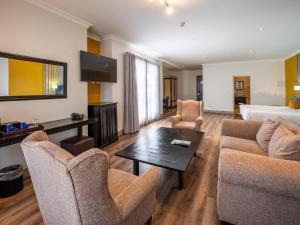 ein Wohnzimmer mit Sofa und Tisch in der Unterkunft ANEW Hotel Highveld Emalahleni in Witbank