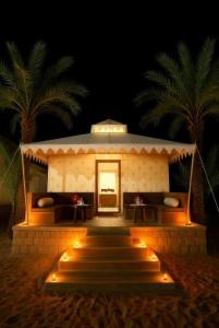 斋沙默尔Desert Villa Resort & Camp Jaisalmer的一栋建筑物，里面有一条楼梯通往一扇带灯的门。