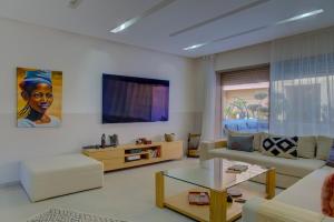 a living room with a couch and a table at Charming Seaside Apartment with Pool & Direct Beach Access in Agadir nʼ Aït Sa