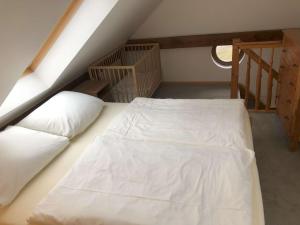 een slaapkamer met een wit bed op zolder bij Ferienwohnung Kalksee in Braunsberg